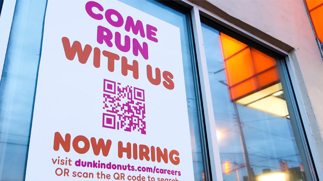 A Dunkin' Donut Window with a Job Hiring Sign A Dunkin' Donut Window with a Job Hiring Sign