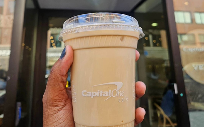 A Hand holding a Capital One Cafe Handcrafted Beverage