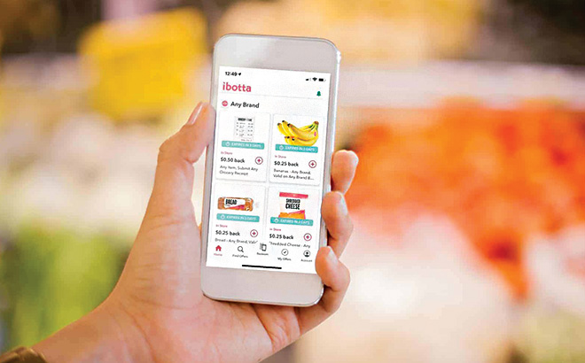 A Hand Holding a Phone with the Ibotta App On It