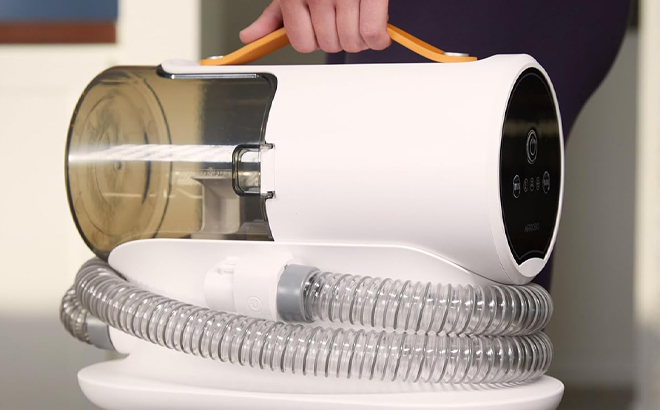 A Hand holding an Airrobo Pet Grooming Vacuum