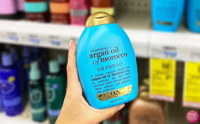 a Hand Holding OGX Argan Oil Shampoo