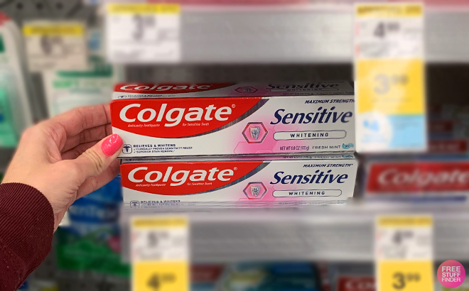 A Person Holding the COlgate Sensitive Toothpaste on a Shelf at Walgreens