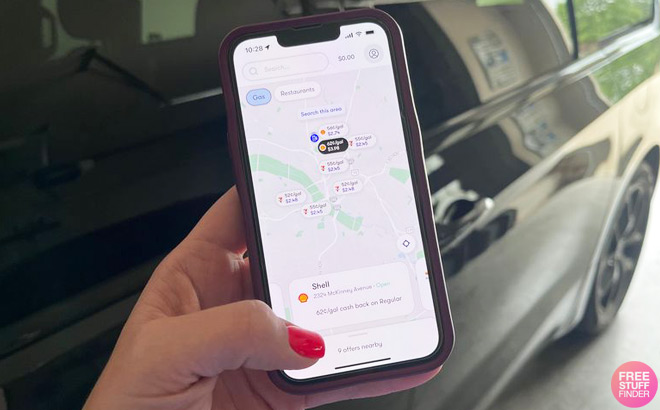 A Person in Front of a Car Holding a Phone and Checking Upside App A Person in Front of a Car Holding a Phone and Checking Upside App
