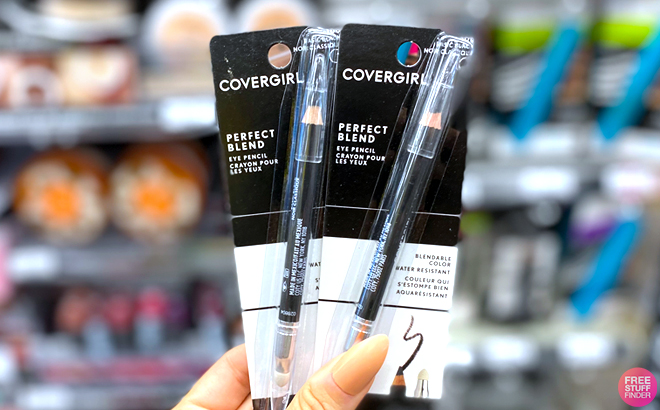 A Hand Holding Two CoverGirl Eye Pencils A Hand Holding Two CoverGirl Eye Pencils