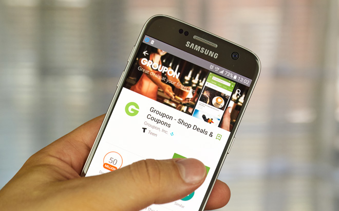 Hand Holding a Mobile Device Showing Groupon App