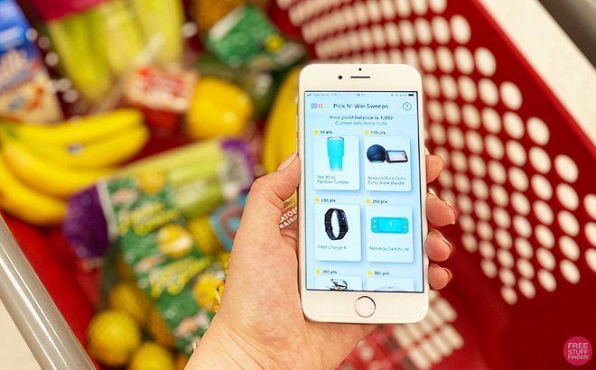 Hand Holding Phone with National Consumer Panel in Front of a Shopping Basket Hand Holding Phone with National Consumer Panel in Front of a Shopping Basket